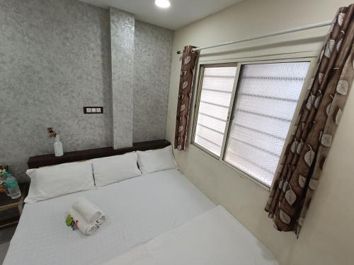 a bedroom with a large white bed with a window at New SHIPRA TOWER in Ujjain