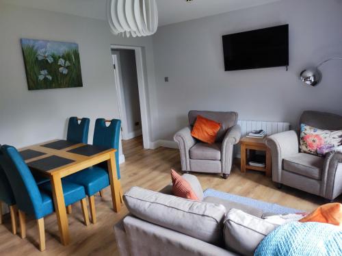 a living room with a couch and chairs and a table at Apartments at Ballinsheen House & Gardens in Lisdoonvarna