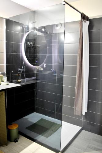 une salle de bain avec une douche avec un lavabo et un miroir dans l'établissement Studio Terrasse entre ville et port, à Porto-Vecchio