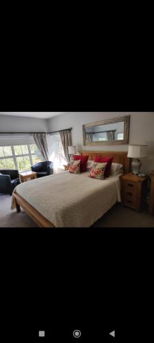 a bedroom with a large bed with red pillows at Apartments at Ballinsheen House & Gardens in Lisdoonvarna