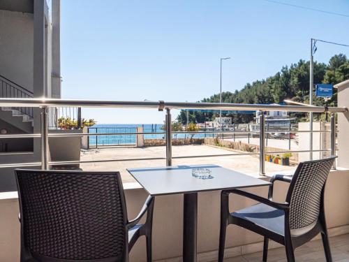 a table and chairs on a balcony with a view of the ocean at Endless Blue Himara in Himare