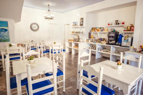 a dining room with white tables and chairs at Cyclades Hotel in Karterados