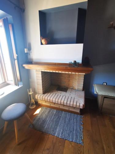 a living room with a fireplace with a flat screen tv at Traditional stone guesthouse in Agios Andreas