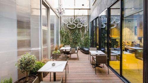 a restaurant with tables and chairs on a balcony at Campanile Rennes Centre - Gare in Rennes