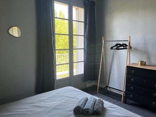 une chambre avec un lit, une commode et une fenêtre dans l'établissement Bord de l'eau, grand appartement, à Saint-Pryvé-Saint-Mesmin