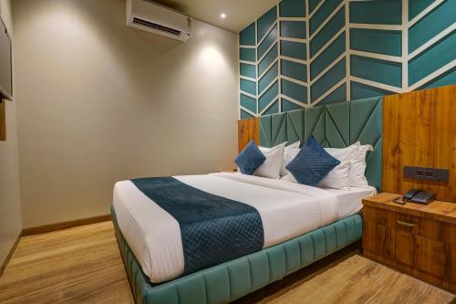 a bedroom with a large bed with blue and green walls at Starville Hotel Andheri MIDC in Mumbai