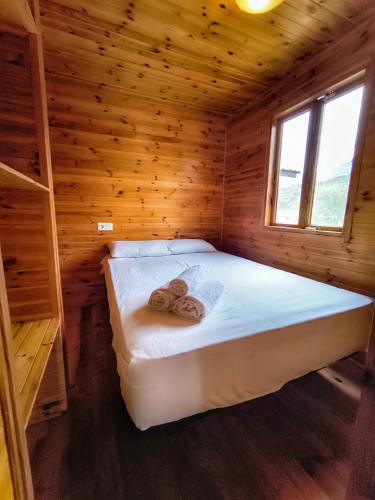 a bedroom with a bed in a wooden cabin at ARES Ecoresort in Camarasa