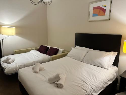 two beds in a hotel room with towels on them at Green Ariana Hotel - near Wembley and central London in London