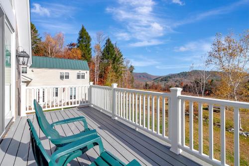 a deck with two chairs sitting on it at Panoramic Mountain Views with Hot Tub in Jamaica