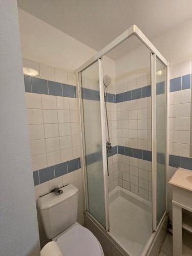 une salle de bain avec des toilettes blanches et une douche dans l'établissement birdie-deauville, à Deauville