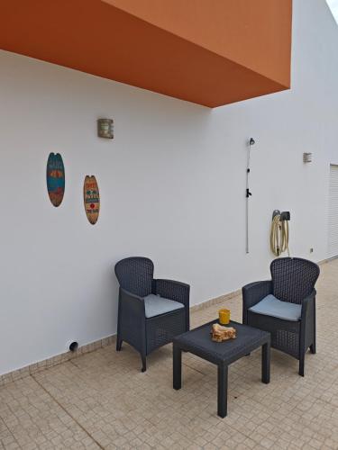 two chairs and a table in a room at Quarto privado Alentejo Litoral in Grândola