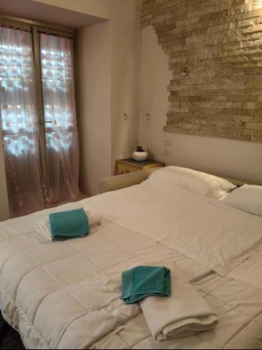 a white bed with two towels on top of it at Sweet home Lago di Garda in Prevalle