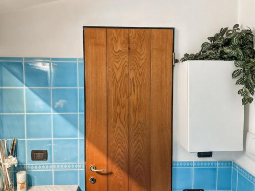 a wooden door in a kitchen with blue tiles at Golfo Paradiso Home in Sori