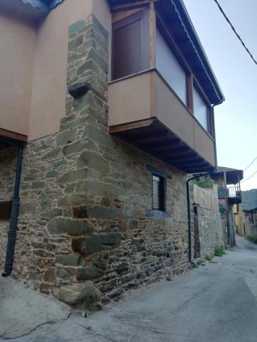 a building with a balcony on the side of it at Casa del patio in Villanueva de Valdueza