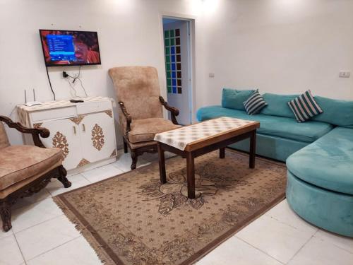ein Wohnzimmer mit einer Couch und einem Tisch und Stühlen in der Unterkunft شقة مميزة بحر مباشر سيدى بشر in Alexandria