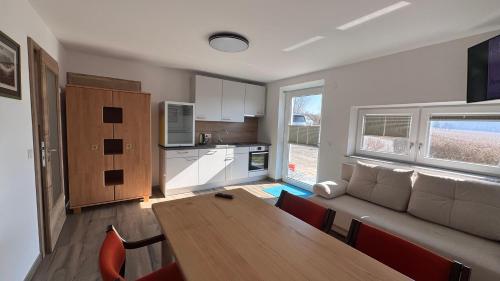 a kitchen and living room with a table and a couch at Bergland Top 4-1 in Petzenkirchen