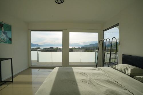 a bedroom with a bed in front of a large window at Montreux panoramic view with garden in Montreux