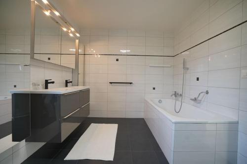 a white bathroom with a tub and a sink at Montreux panoramic view with garden in Montreux