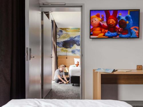 a child sitting on the floor in a hotel room at Ibis Styles Hobart in Hobart