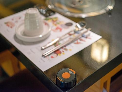 a table with chopsticks and plates on a table at Tama Boutique Hotel in Bandung