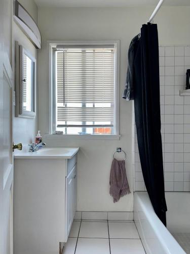 a bathroom with a sink and a tub and a window at Riverton Place NoHo in Los Angeles