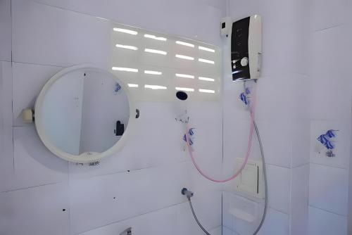 a white bathroom with a mirror and a sink at BAO Patong Beach Phuket - เบา ป่าตอง in Patong Beach