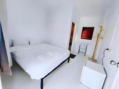 a white bedroom with a bed and a mirror at XX BAO Patong Beach Phuket - เบา ป่าตอง in Patong Beach