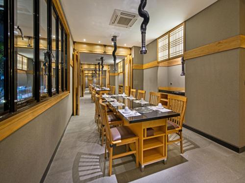 a dining room with a long table and chairs at Tama Boutique Hotel in Bandung