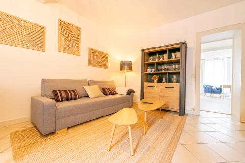 un salon avec un canapé et une table dans l'établissement Appartement de l'ammonite, à La Rochelle