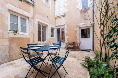 une cour avec une table et des chaises dans l'établissement Appartement de l'ammonite, à La Rochelle