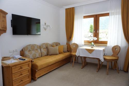 a living room with a couch and a table at Landhaus Achental in Pertisau