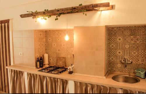 a kitchen counter with a sink and a stove at Vicoli del borgo in Ruffano