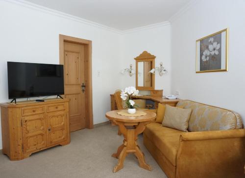 a living room with a couch and a tv at Landhaus Achental in Pertisau