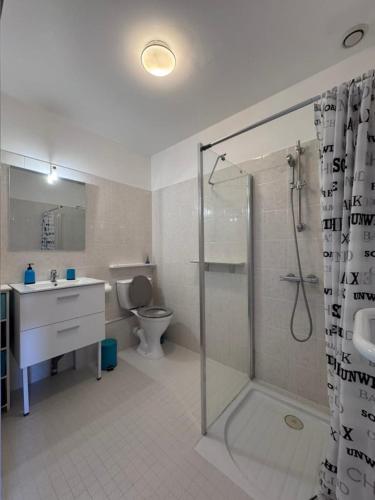 a bathroom with a shower and a sink and a toilet at Dunes Apart-Hotel - Kiwi Residence in Aytré