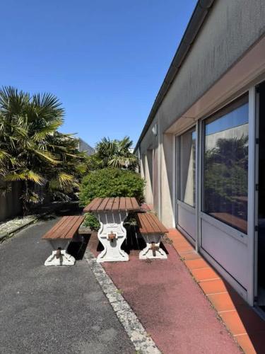 two tables and benches on the side of a building at Dunes Apart-Hotel - Kiwi Residence in Aytré