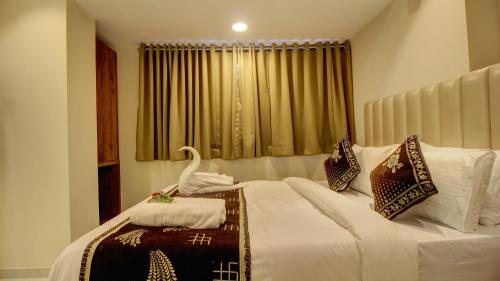 a bedroom with a bed with a swan on it at Hotel Sapphire Inn Residency in Thane