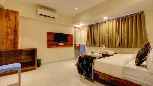 塞恩Hotel Sapphire Inn Residency的房间里有一张床和一台电视的卧室
