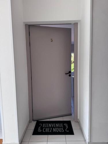 a white door with a sign in front of it at Dunes Apart-Hotel - Kiwi Residence in Aytré