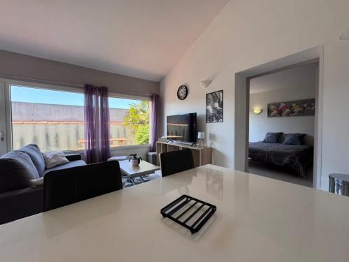 a kitchen and living room with a large white table at Dunes Apart-Hotel - Kiwi Residence in Aytré