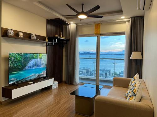 a living room with a tv and a large window at Sea Moon full Apartment in Ha Long