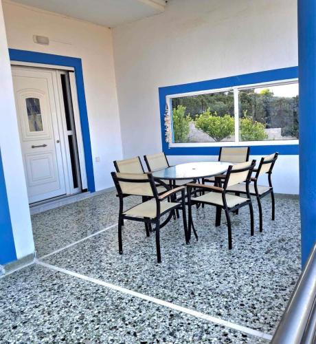 a dining room with chairs and a table and a window at Komi Blue in Kómi