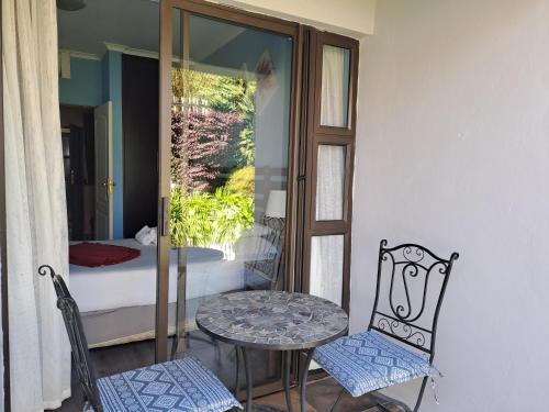 a room with a table and a chair and a bed at Tribute Guest House Matala in Maseru