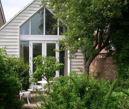 a white house with a window and a table at The White Barn near Cambridge in Huntingdon