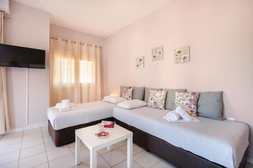 ein Hotelzimmer mit zwei Betten und einem Tisch in der Unterkunft Almyra Apartments by RentalsPro - Hanioti Halkidiki in Chaniotis