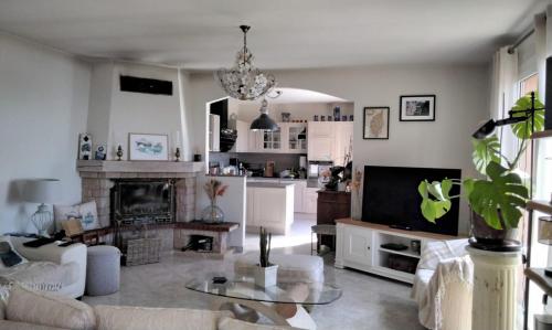 un salon avec un canapé et une télévision dans l'établissement L'Olivier, à Sainte-Agnès