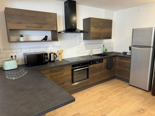 une cuisine avec des appareils en acier inoxydable et des armoires en bois dans l'établissement Escapade Marine, à Salles-sur-Mer