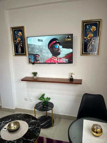 a living room with a flat screen tv on the wall at Lekker Estate in Yaoundé