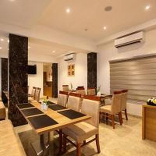 a dining room with a table and a table and chairs at Park Residency Kodungallur in Trichūr
