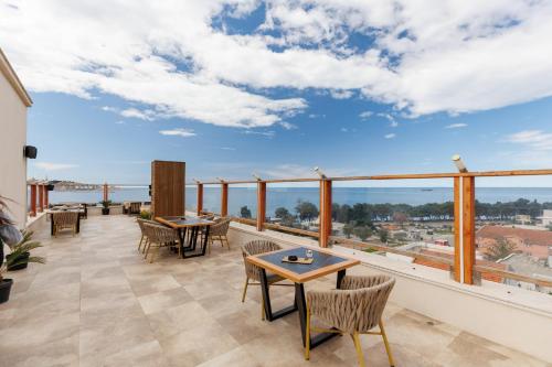 a balcony with tables and chairs and a view at XIO Apartments in Bar