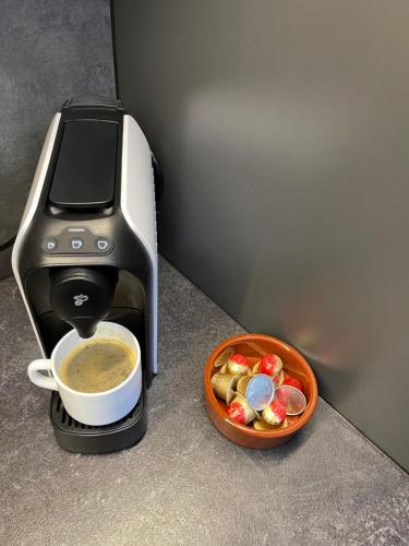 a espresso machine with a cup of coffee next to a bowl of food at Residential Apartment in Chişinău